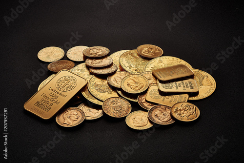 Yellow gold bars and coins isolated on black background