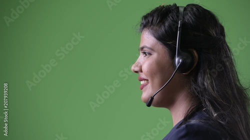 Young overweight beautiful Indian businesswoman against green background