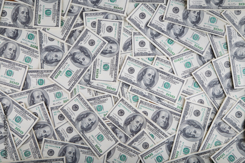 Paper 100 dollar bills spread out on the plane in a chaotic manner