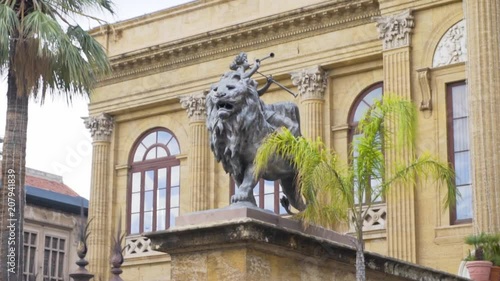 Lion statue on the street of the city in Europe. Stock. Stone sculpture of a lion with buildings in the background photo