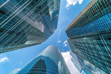 Low angle shot of modern glass city buildings during sunny day. Wide lens effect.