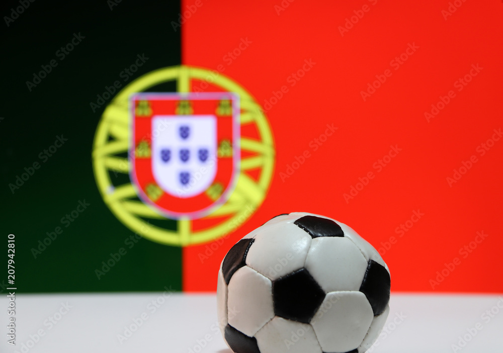 Small football on the white floor and Portuguese nation flag background. The concept of sport. Small football on the white floor and Portuguese nation flag background. The concept of sport.