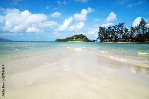 Tropical sandy beach under the blue cloudy sky photo