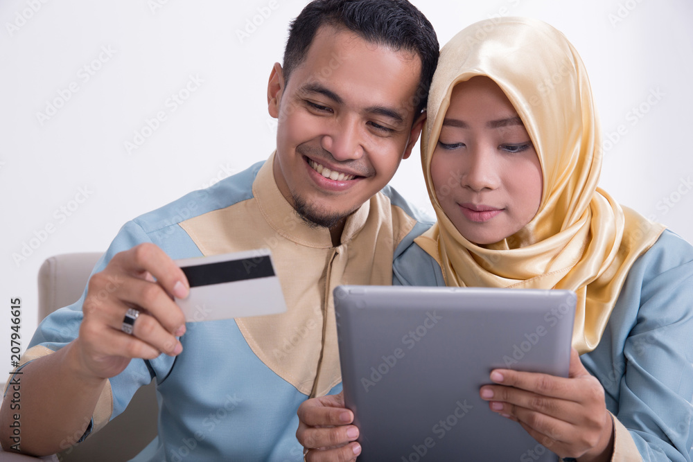 muslim couple on a couch with tablet muslim couple on a couch with tablet