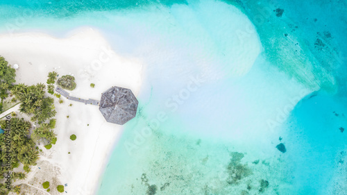 Aerial top view tropical island white sand beach with blue lagoon in Maldives island, Beautiful tropical maldives resort hotel.