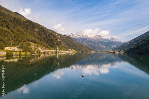 Isolated boat on the alpine lake, lake of Poschiavo in the Canton Grisons, Switzerland