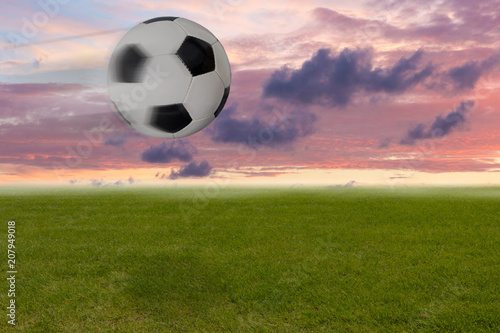 Fliegender Fußball vor rotem Himmel am Abend