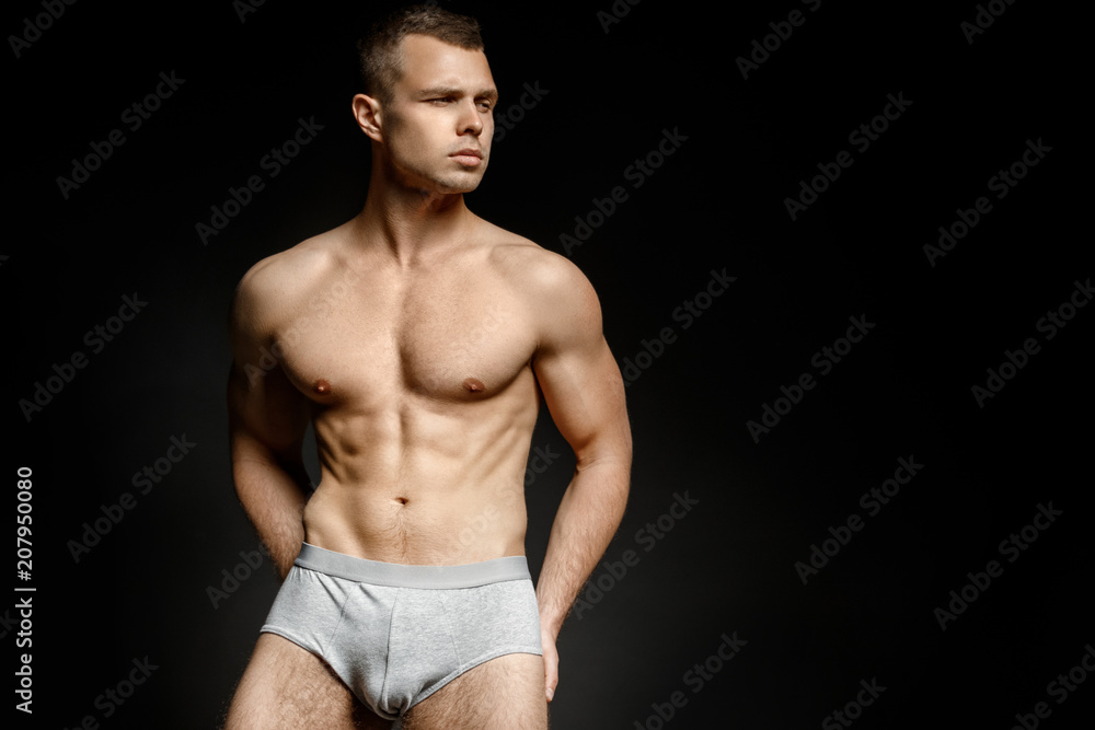 Guy in grey underwear on black background Guy in grey underwear on black background