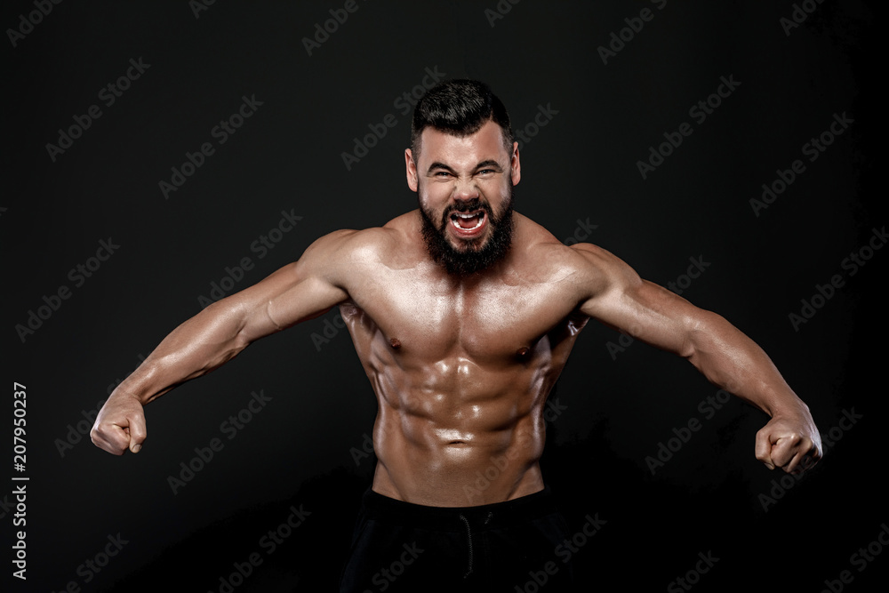 Handsome strong bodybuilder posing in studio