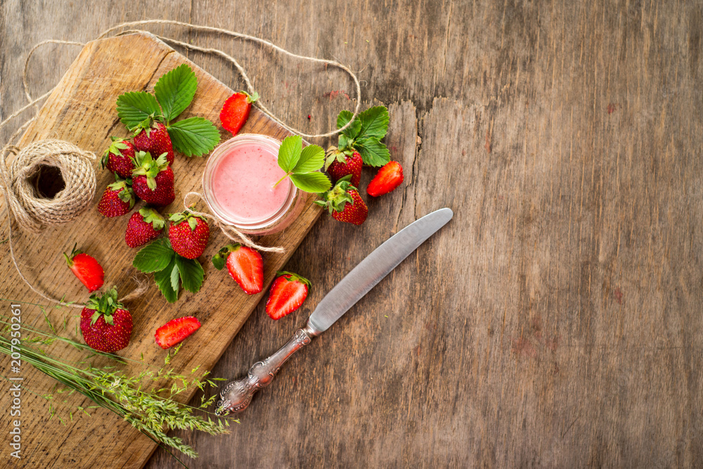 Strawberry smoothies in glass with many strawberries on wooden background. Top view. Copy space Strawberry smoothies in glass with many strawberries on wooden background. Top view. Copy space