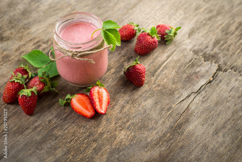 Strawberry smoothies in glass on wooden background. Top view. Copy space