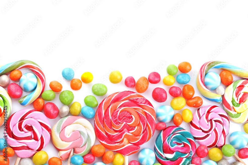 Multicolored lollipops and round candies on a white background. Top view. Isolated.