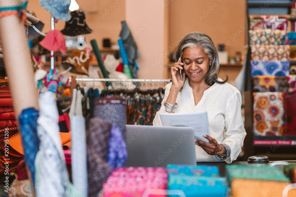 Smiling mature woman at work in her fabric shop