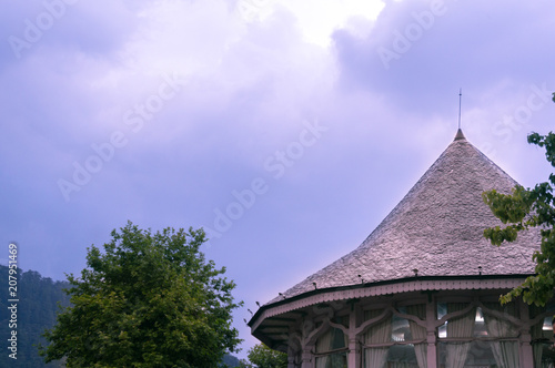 Round building with a conical roof made of bricks shot against a cloudy sky during the evening. Common feature in the buildings of shimla, darjeeling and other hill stations
