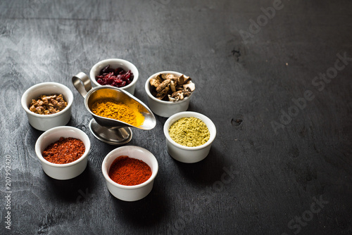 Different spices with raw and dry vegetables on black background. Top view. free space