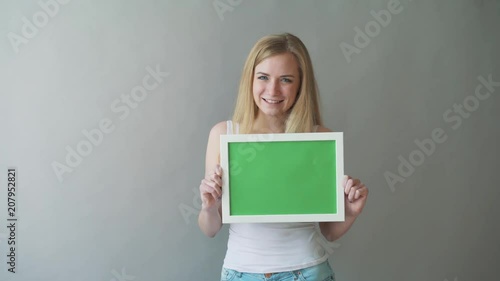 Attractive Woman shows greenkey copyspace with tracking points. photo