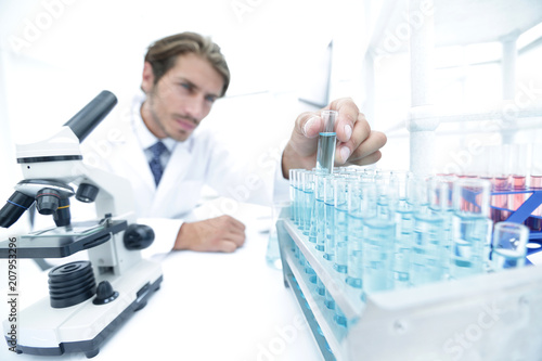 Chemist looking at test-tubes with blue liquids