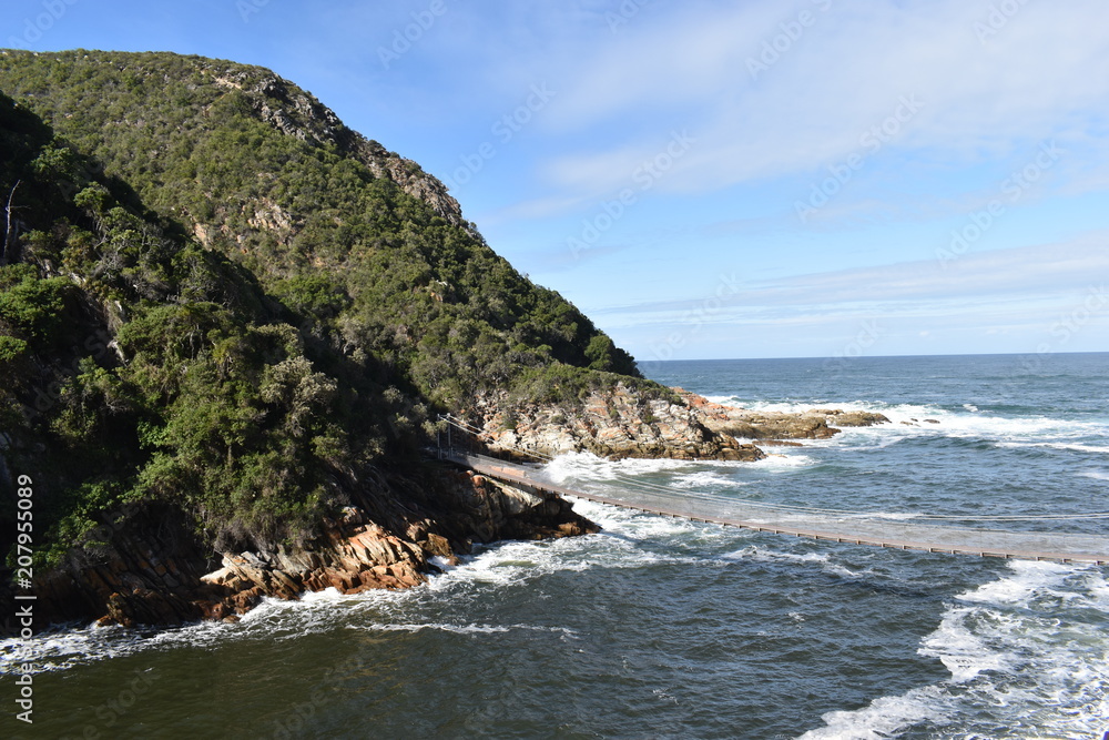 Mountainous Landscape with the beautiful beach and the famous Storms River Bridge at Tsitsikamma National Park in South Africa