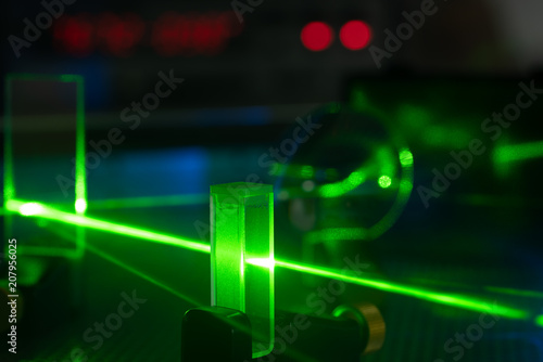 Green laser on optical table in a quantum optics lab. photo