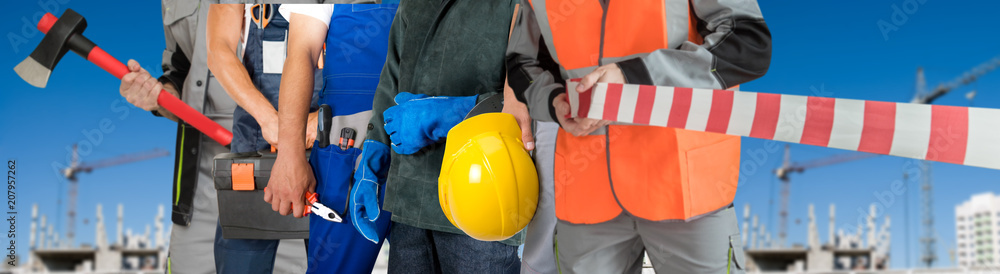 Many workers closeup with equipment on building background Many workers closeup with equipment on building background