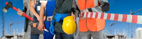 Many workers closeup with equipment on building background