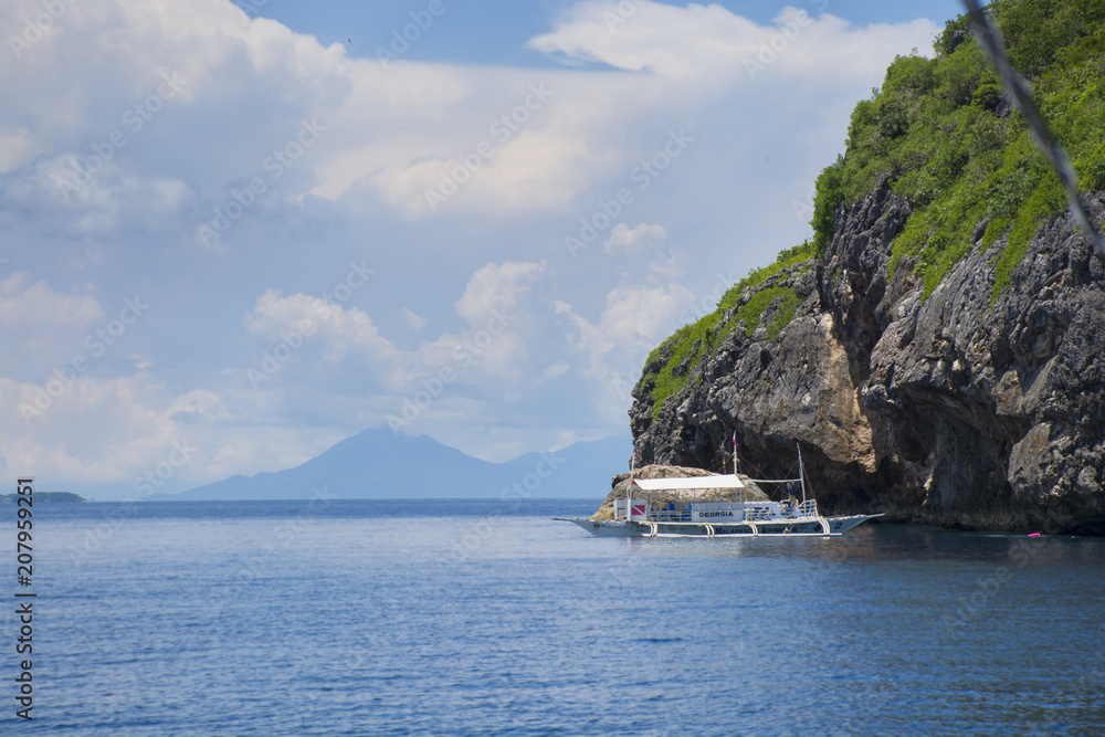 Boat near the rock in sunny day