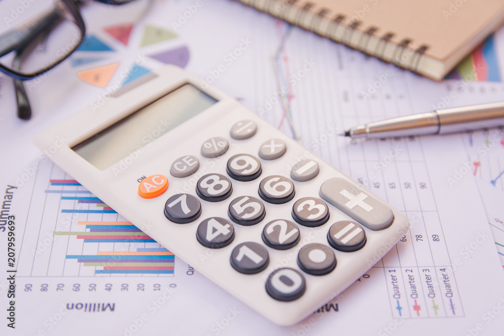 data analyzing with calculator, notebook and pen. on charts and graph to find out the result. data analyzing with calculator, notebook and pen. on charts and graph to find out the result.