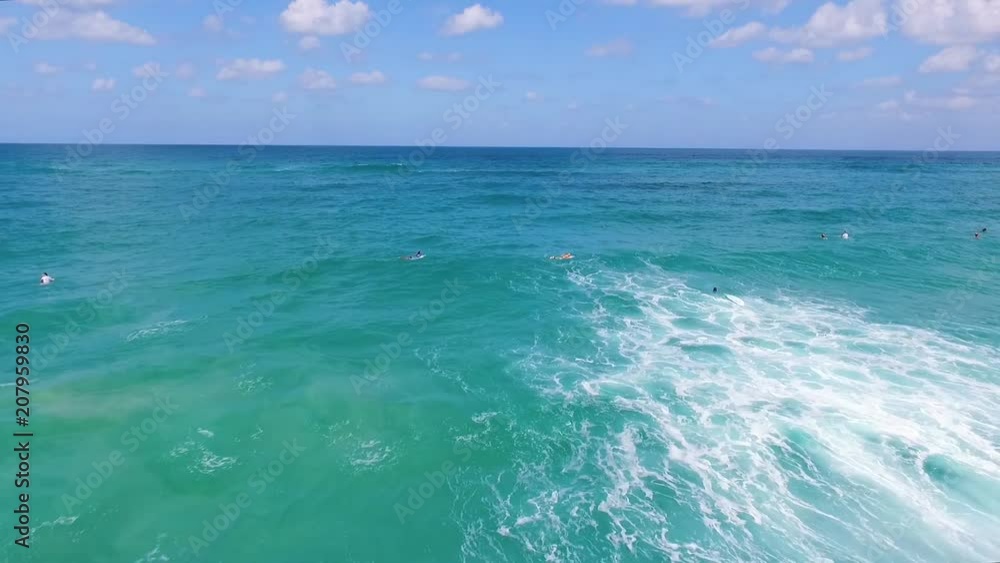 Drone shot of Surfers catching waves, Aerial view of lots of Surfers On Summer Vacation Riding Perfect Breaking Waves. Drone shot of Surfers catching waves, Aerial view of lots of Surfers On Summer Vacation Riding Perfect Breaking Waves.