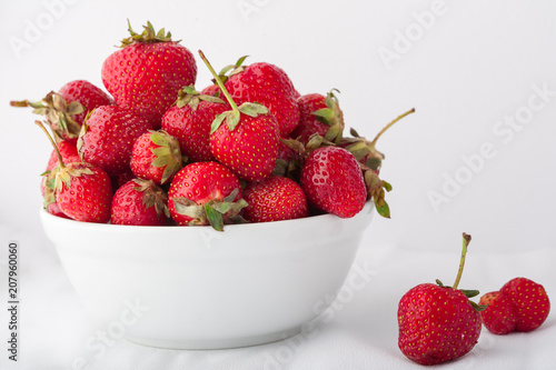  Strawberries in a white bowl on a white background. Copy space. 