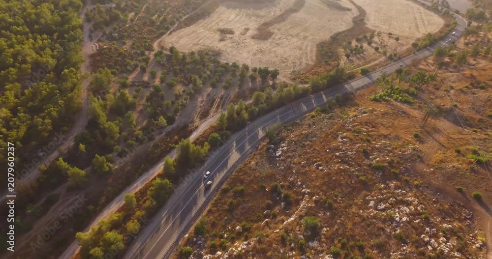 Aerial Shot Of Cars Driving Through Forest Road Drone Travel Countryside. Flight Over The Road With Cars and green trees at sunset golden Aerial Shot Of Cars Driving Through Forest Road Drone Travel Countryside. Flight Over The Road With Cars and green trees at sunset golden