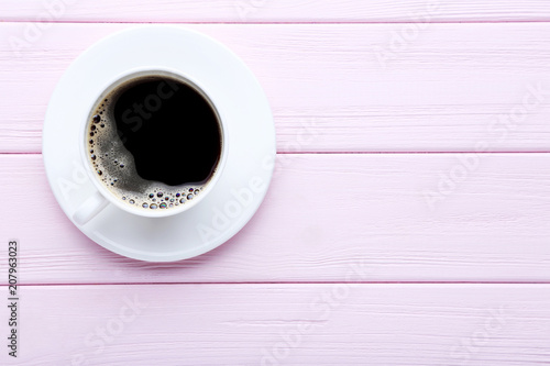 Cup of coffee on pink wooden table