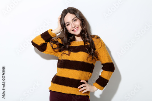 Beautiful young woman in sweater on white background