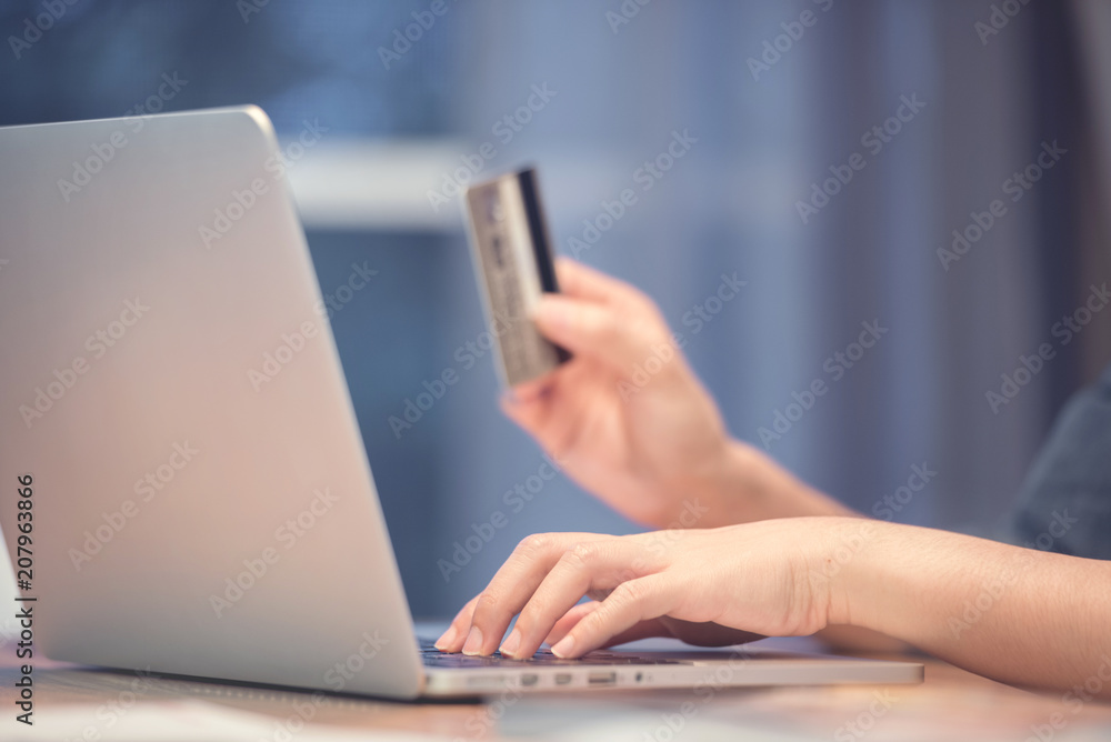 Woman hands holding credit card while using laptop. Online shopping concept. Woman hands holding credit card while using laptop. Online shopping concept.