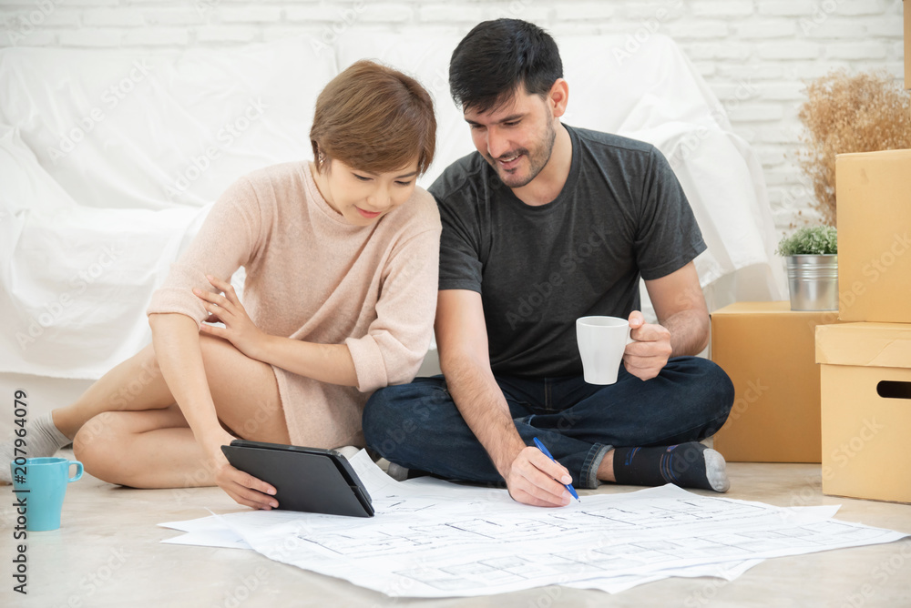Happy young couple planning their new moving house. Happy young couple planning their new moving house.