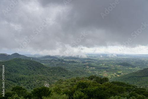 Mallorca  Rainy dark clouds over green mountainous nature landscape from above
