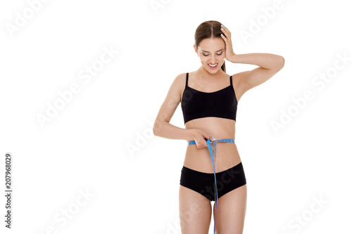 woman measuring waist with blue measuring tape.