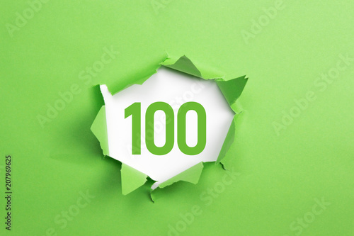 gruene Nummer 100 auf gruenem Papier
