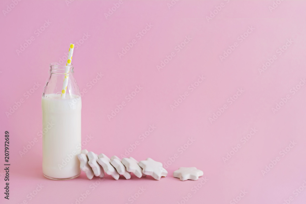 Bottle of milk and cookies shaped stars on pink background Bottle of milk and cookies shaped stars on pink background