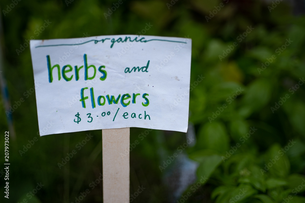 Price Tag for Herbs and flowers in Farmers market. Blurred background.