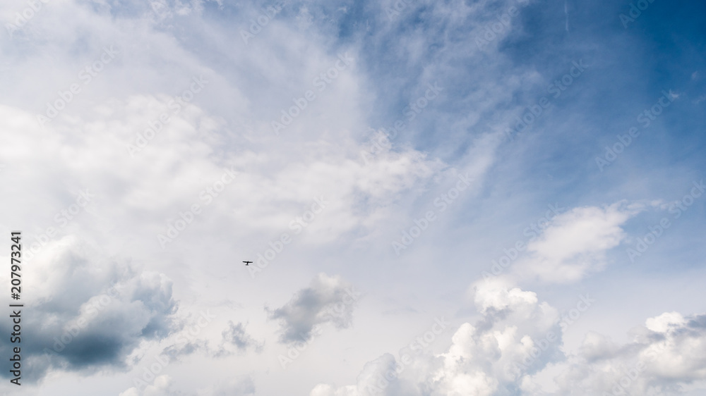 Blue bright sky with clouds and small plane Blue bright sky with clouds and small plane