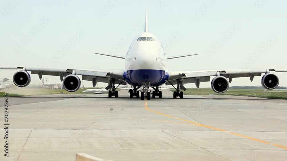 Traffic at the airport. The white passenger plane is moving along the taxiway and getting ready to take off. Traffic at the airport. The white passenger plane is moving along the taxiway and getting ready to take off.