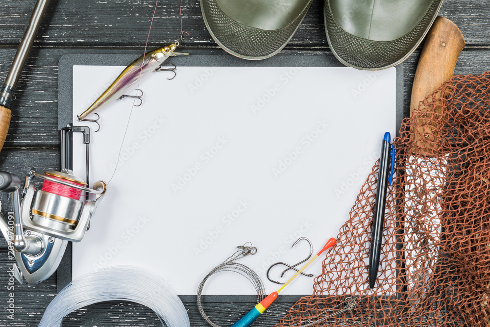 Fishing gear - fishing, fishing, hooks and baits, an old sheet of paper on a wooden background.