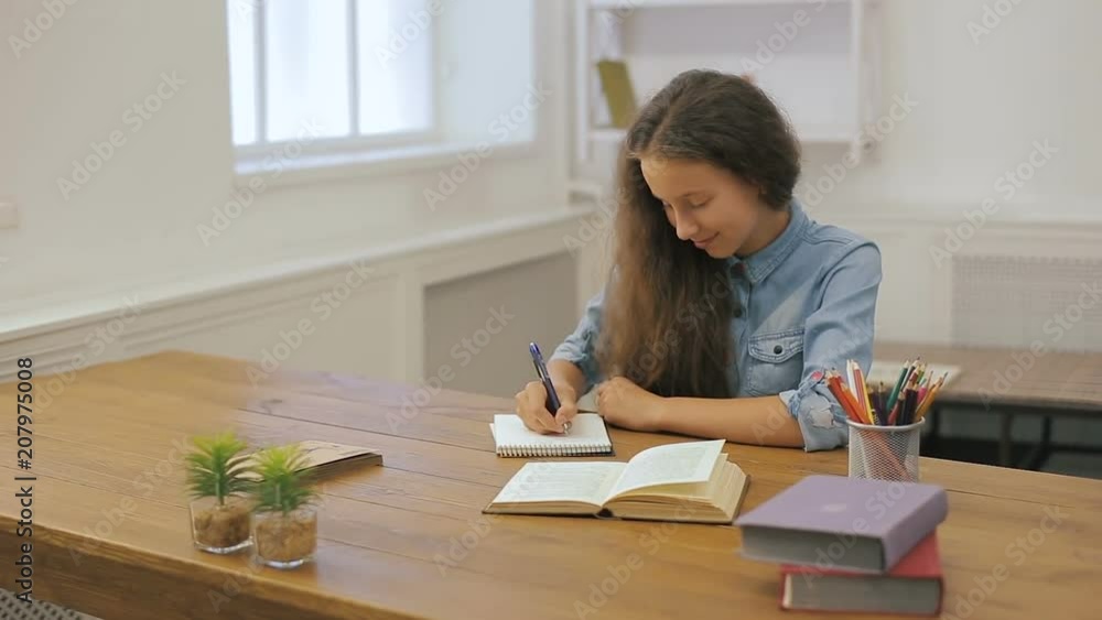Young girl with laptop computer is doing homework. College education. Female student is studying at home. Young girl with laptop computer is doing homework. College education. Female student is studying at home.