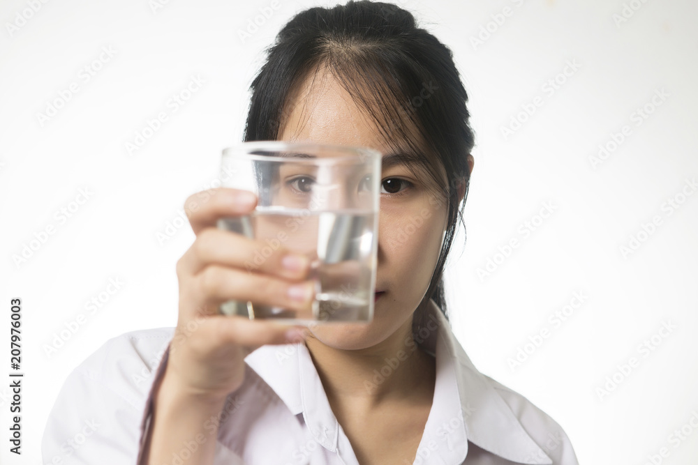 young asian woman looking at a glass of water