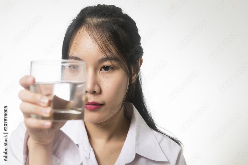 young asian woman looking at a glass of water young asian woman looking at a glass of water
