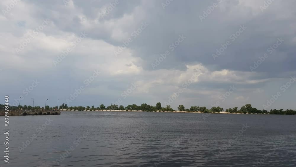 Cityscape and skyline in cloudy sky and river. Sunshine, blue sky. Mysterious clouds are flying very low over river. Cityscape and skyline in cloudy sky and river. Sunshine, blue sky. Mysterious clouds are flying very low over river.