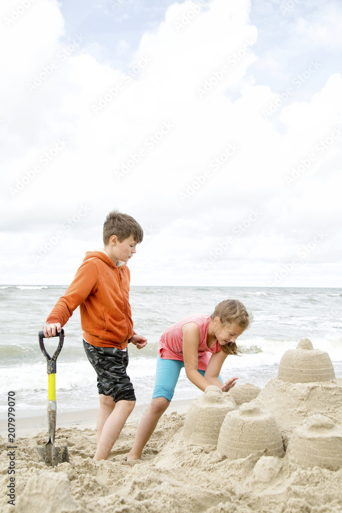 Cute children building sandcastle Cute children building sandcastle
