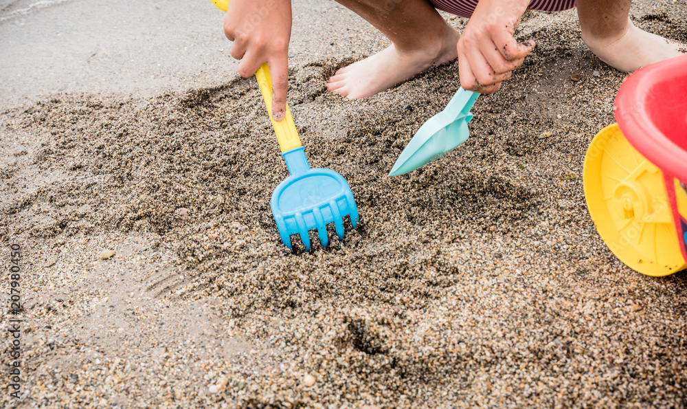 boy playing on the seashore with beach toys boy playing on the seashore with beach toys