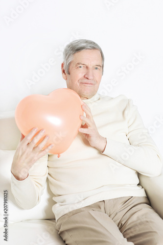 elderly man showing a big heart.isolated on white