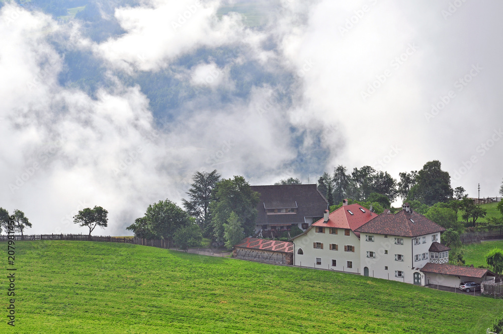 Alpine houses in clouds